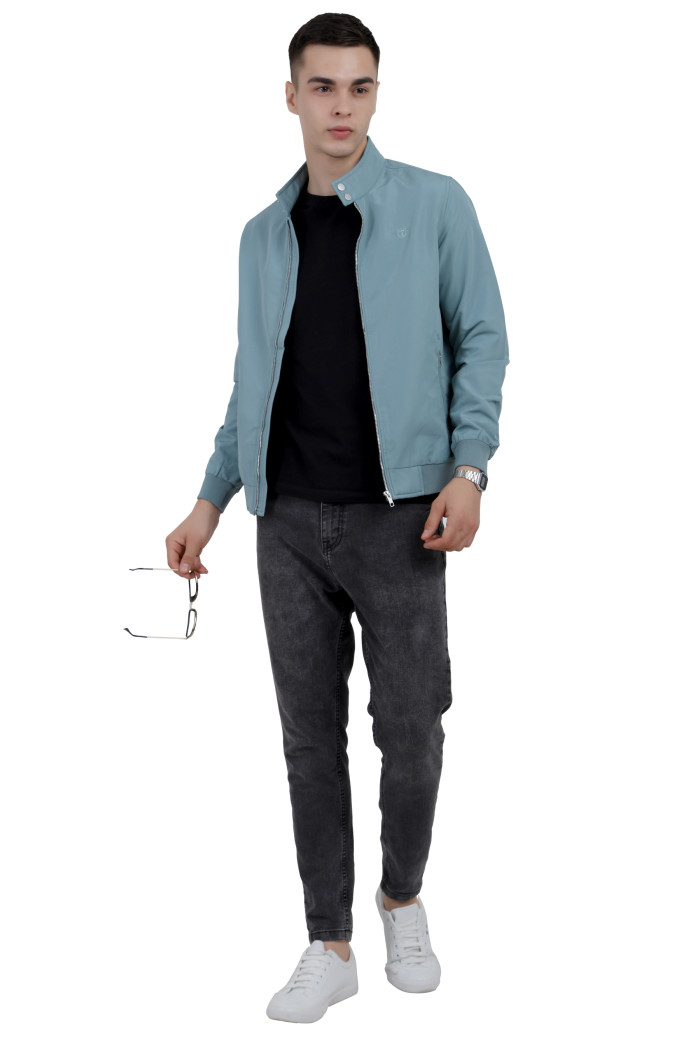 :A tilted pose of a man wearing an Aqua Blue Finish Lightweight Jacket with high neck collar, zipper closure and pocket in hand designed for casual winter layering and comfort.